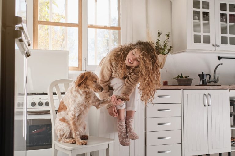 happy-woman-with-dog-in-kitchen